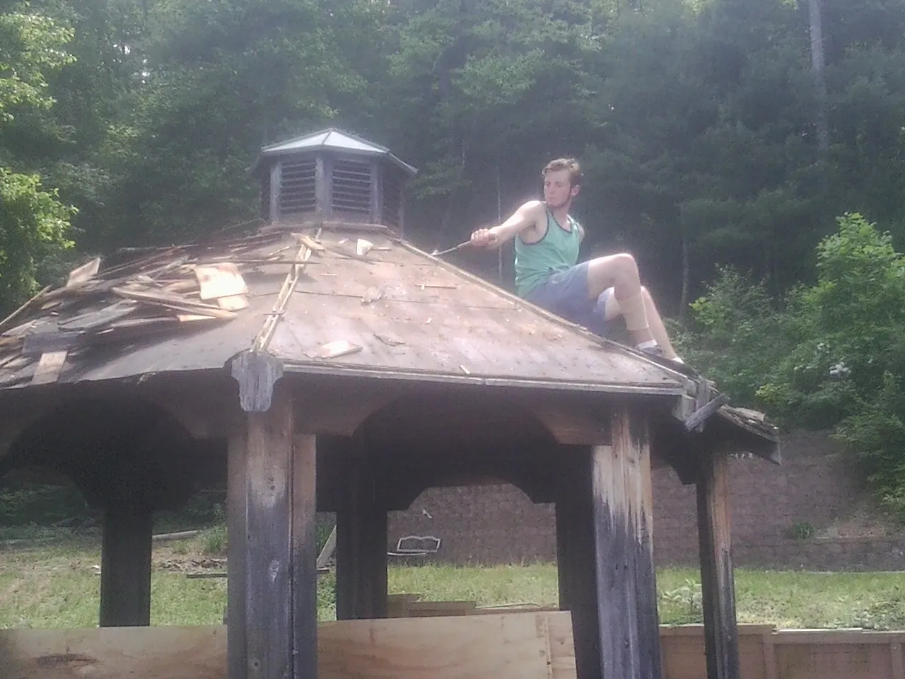 Tearing the old roof off a wooden gazebo before new shakes in Shelter Island Heights