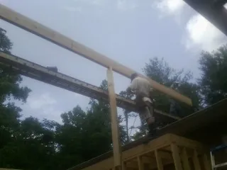 Carpenter setting a ridge beam over a new addition frame — Ice Dam Removal by Roofing Brothers in Shelter Island Heights