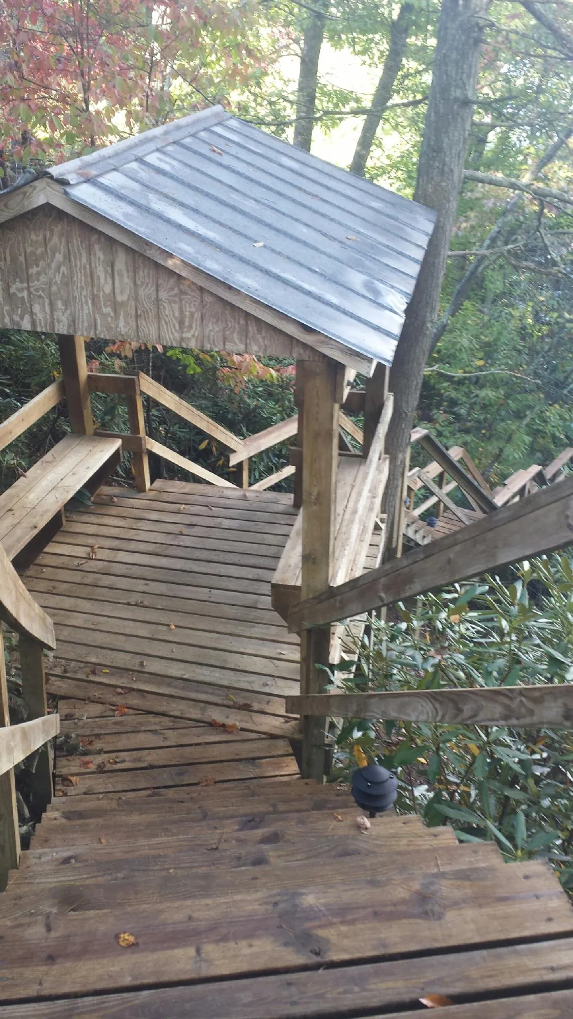 Metal roofed shelter over wooden steps on a wooded walkway — Skylight Repair & Installation work by our crew in Shelter Island Heights