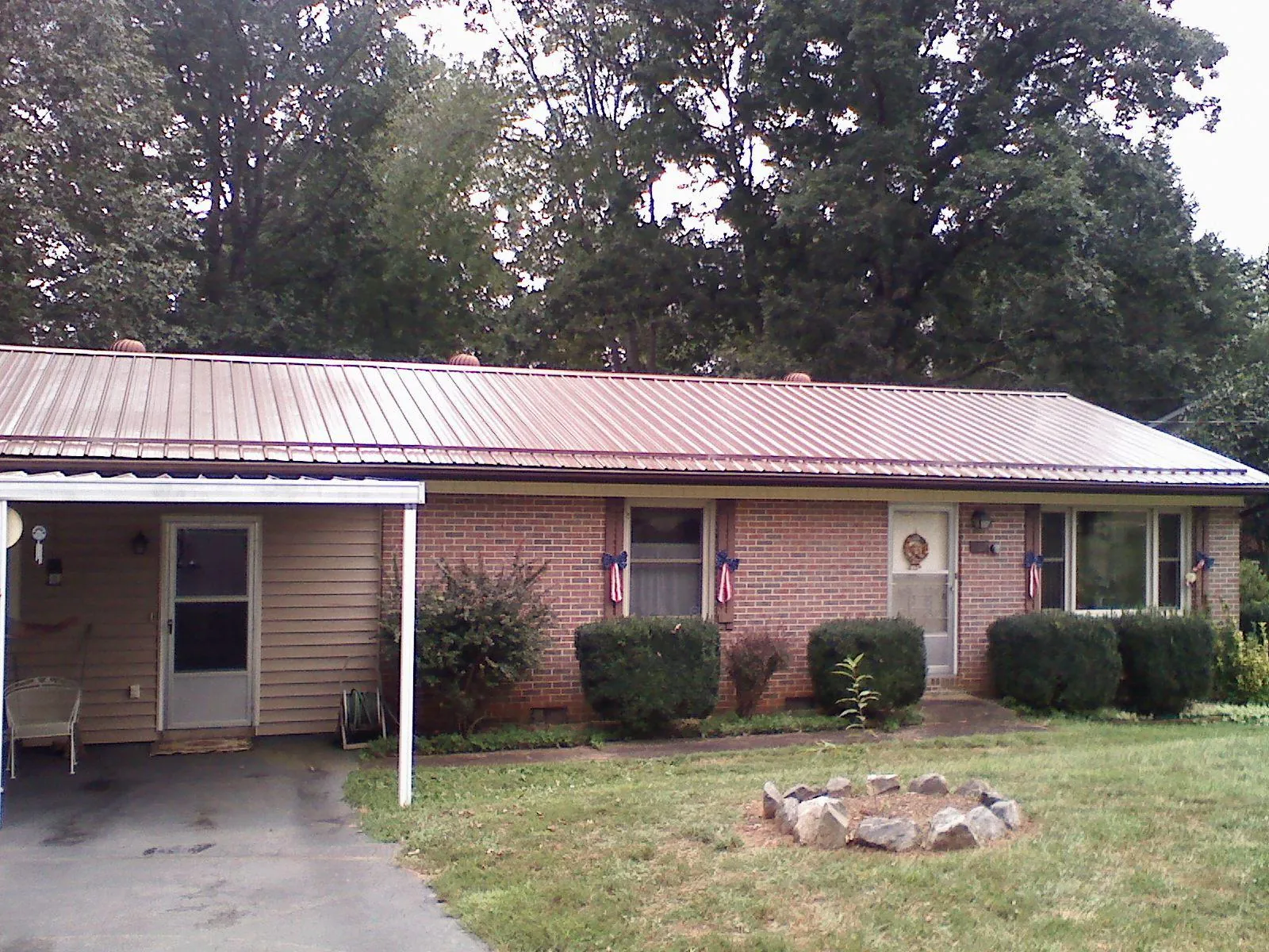 Bronze metal roof and carport on a brick ranch home — Roof Repair work by our crew in Shelter Island Heights